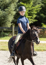 Young rider wearing the tights during a riding session, demonstrating the comfort and flexibility provided by the design