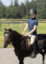 Young rider wearing the Ice Fil® Lite Short Sleeve Riding Shirt during a lesson, demonstrating comfort and flexibility